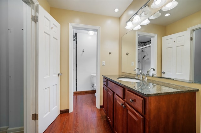 bathroom featuring hardwood / wood-style flooring, toilet, and vanity