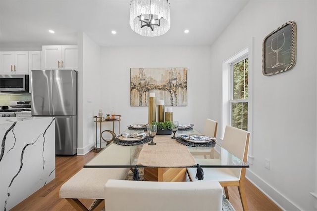 dining room featuring light wood-type flooring and a chandelier