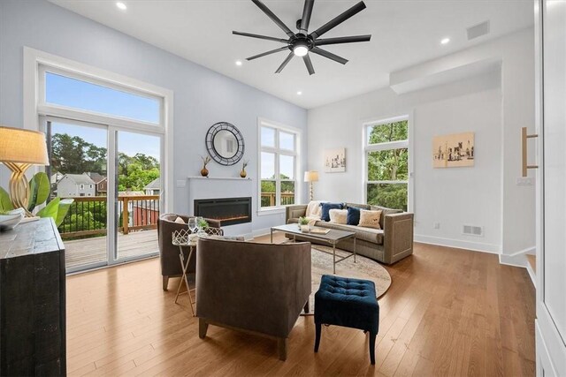 living room with ceiling fan and light hardwood / wood-style flooring