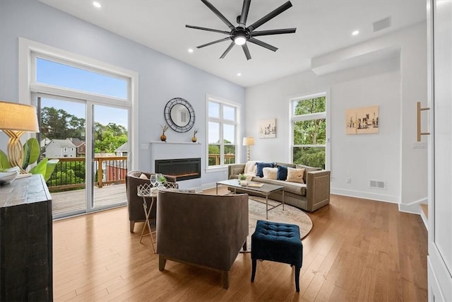 living room featuring light hardwood / wood-style flooring and ceiling fan