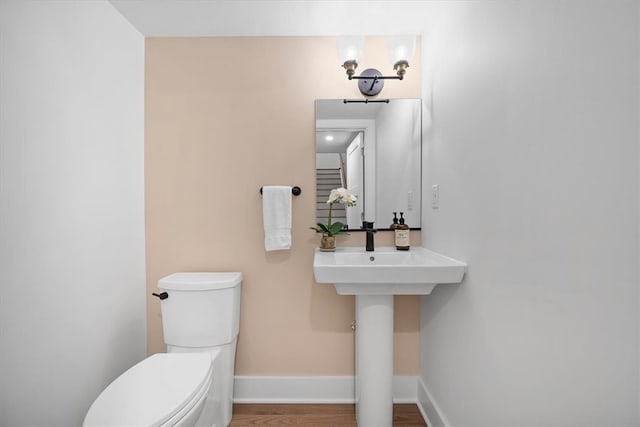 bathroom with hardwood / wood-style flooring and toilet