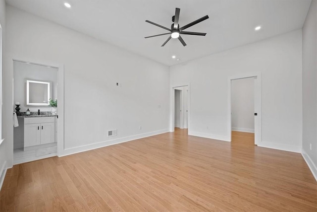 unfurnished living room featuring light wood-type flooring, sink, and ceiling fan