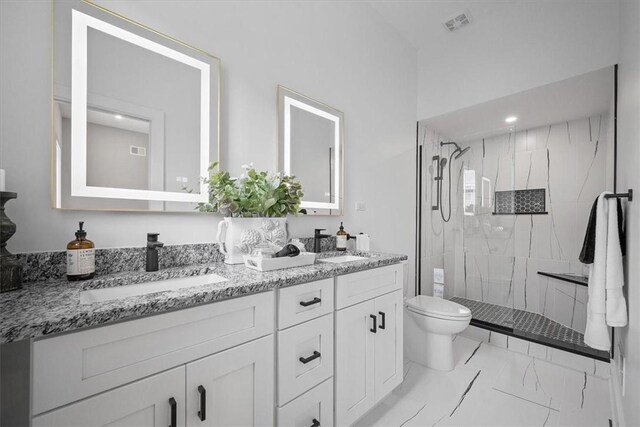 bathroom with tile patterned floors, toilet, dual vanity, and a shower with shower door