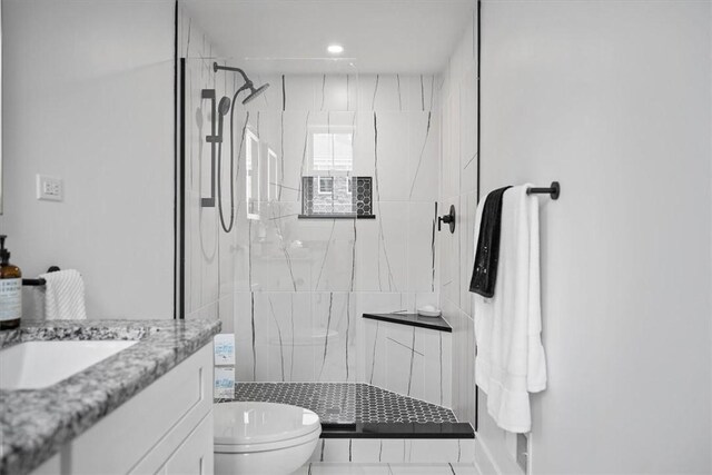 bathroom featuring tile patterned flooring, an enclosed shower, toilet, and vanity