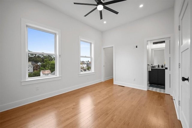 unfurnished bedroom with light wood-type flooring, ensuite bathroom, and ceiling fan