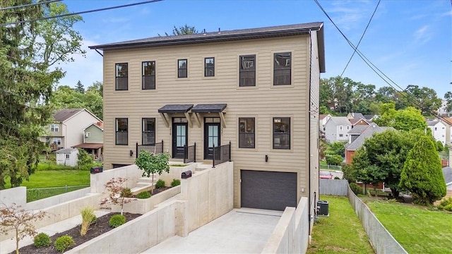 view of front facade featuring a garage, cooling unit, and a front yard