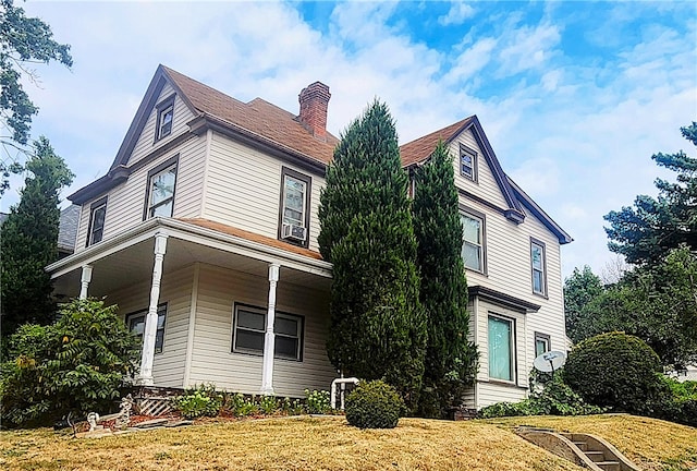 view of property exterior with a porch and a yard