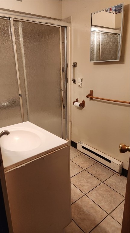 bathroom with baseboard heating, vanity, tile patterned flooring, and a shower with shower door