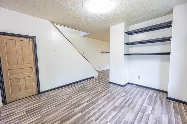 interior space with a textured ceiling and wood-type flooring