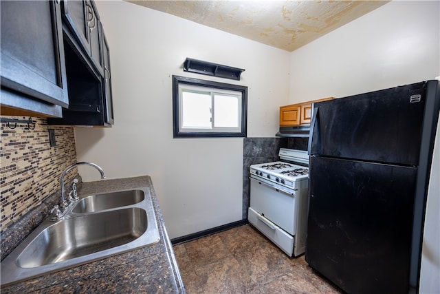 kitchen with decorative backsplash, dark tile patterned flooring, sink, white gas stove, and black fridge