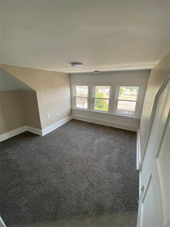 empty room with dark carpet and plenty of natural light