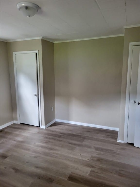 unfurnished bedroom featuring ornamental molding and wood-type flooring