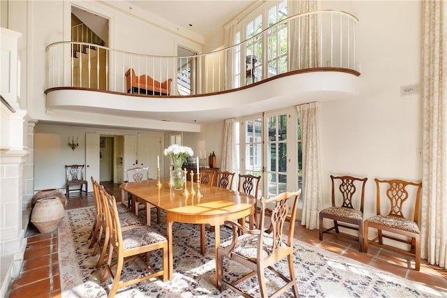 dining area featuring a towering ceiling and decorative columns