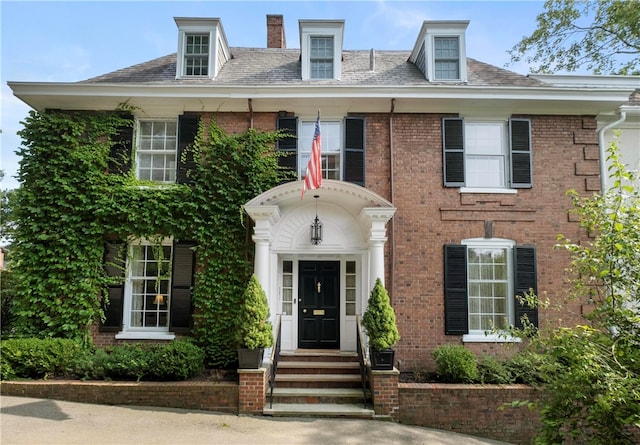 colonial-style house featuring central AC unit