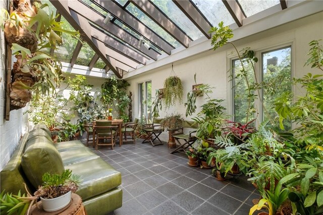 sunroom / solarium with a healthy amount of sunlight and lofted ceiling with skylight