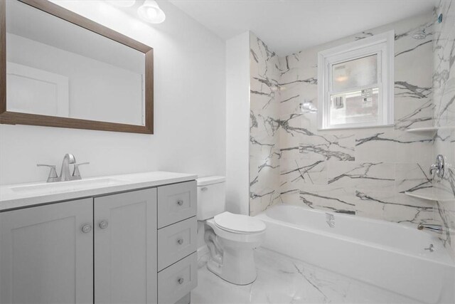 full bathroom with tile patterned flooring, tiled shower / bath, vanity, and toilet