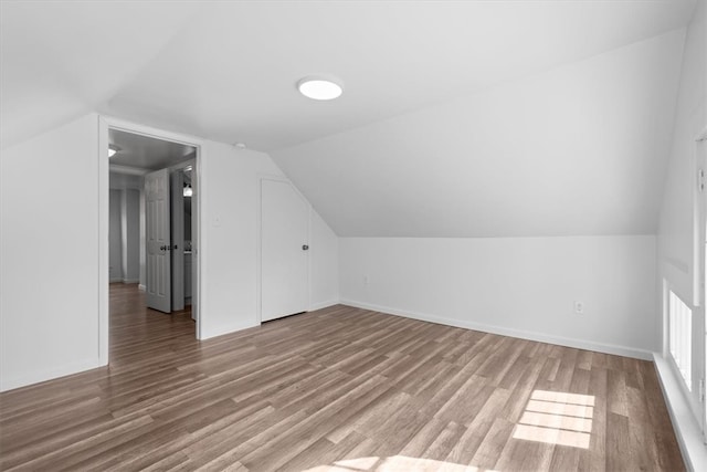 bonus room with vaulted ceiling and wood-type flooring