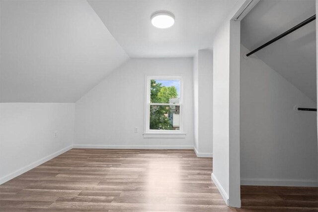 bonus room with hardwood / wood-style flooring and lofted ceiling