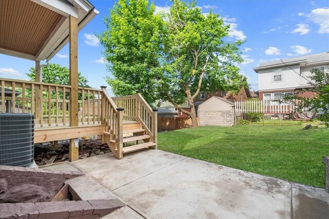 view of patio with central AC unit, a deck, and a shed