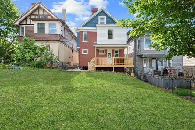 back of house with a deck and a lawn