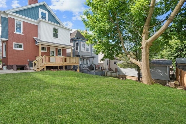 back of property with a deck, central AC unit, and a lawn