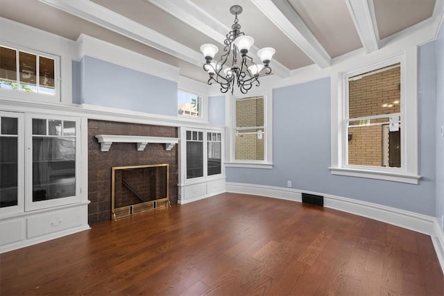 unfurnished living room featuring beamed ceiling, dark hardwood / wood-style floors, and an inviting chandelier