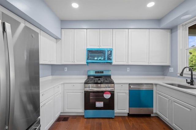 kitchen featuring white cabinetry, appliances with stainless steel finishes, sink, and dark hardwood / wood-style flooring