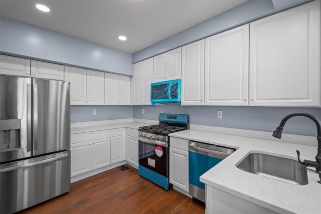 kitchen with sink, white cabinetry, dark wood-type flooring, and stainless steel appliances