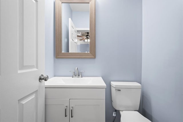 bathroom with ceiling fan, vanity, and toilet