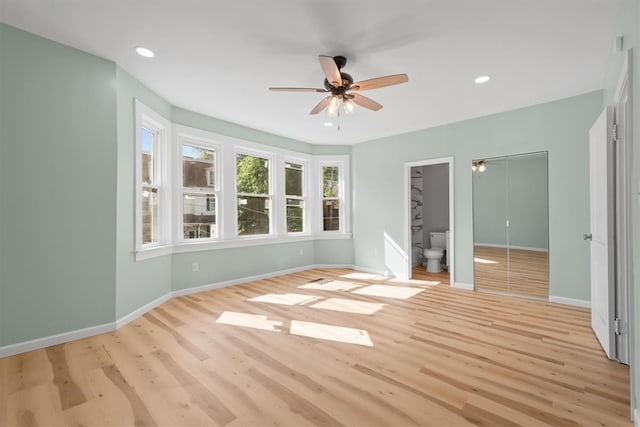 unfurnished bedroom with ceiling fan, ensuite bathroom, and light hardwood / wood-style floors