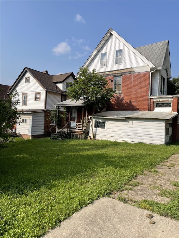 back of house with a lawn