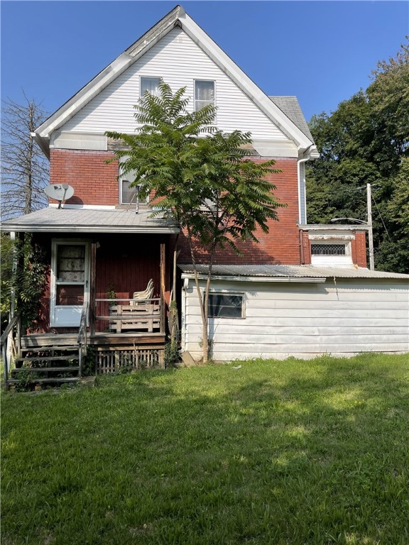 rear view of house featuring a yard