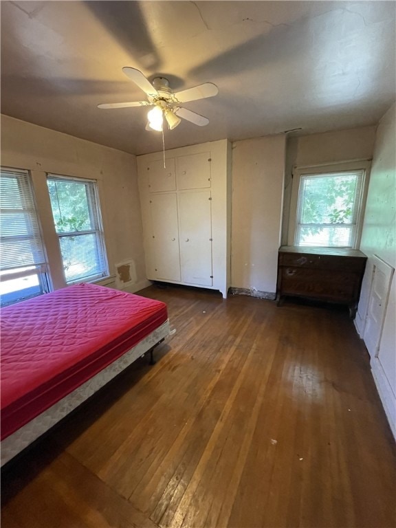 bedroom with multiple windows, ceiling fan, and wood-type flooring