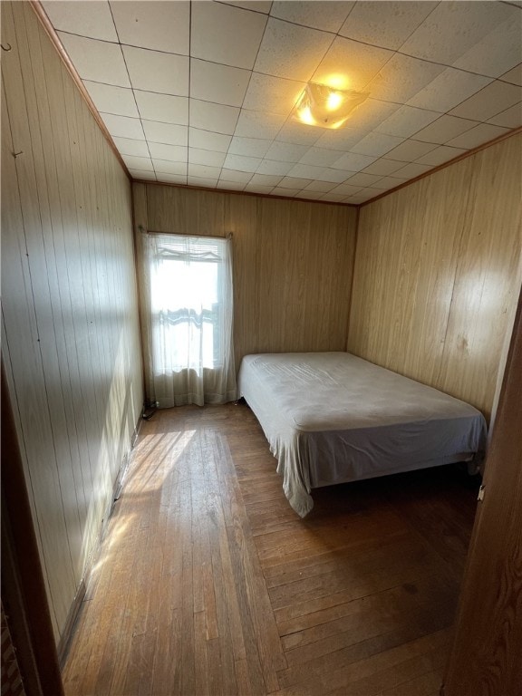 unfurnished bedroom featuring hardwood / wood-style floors and wood walls