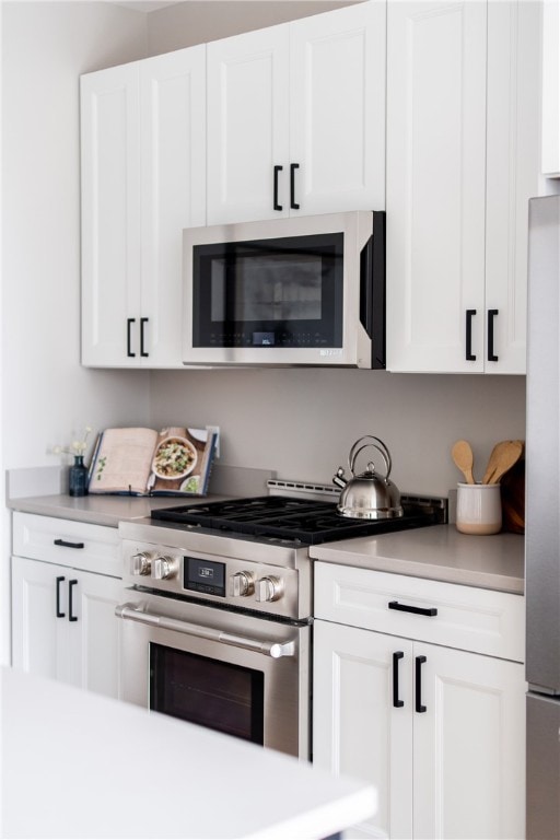 kitchen with white cabinets and appliances with stainless steel finishes