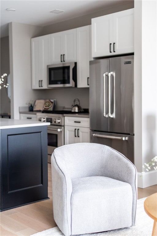 kitchen featuring white cabinetry, light hardwood / wood-style flooring, and appliances with stainless steel finishes