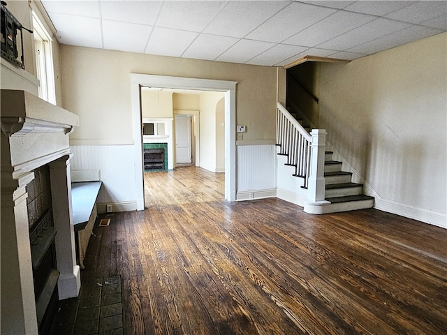 unfurnished living room featuring a paneled ceiling and wood-type flooring