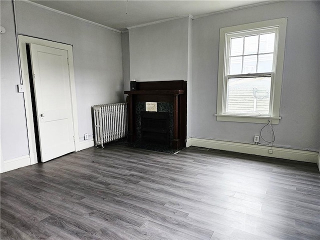 unfurnished living room with crown molding, hardwood / wood-style floors, and radiator heating unit