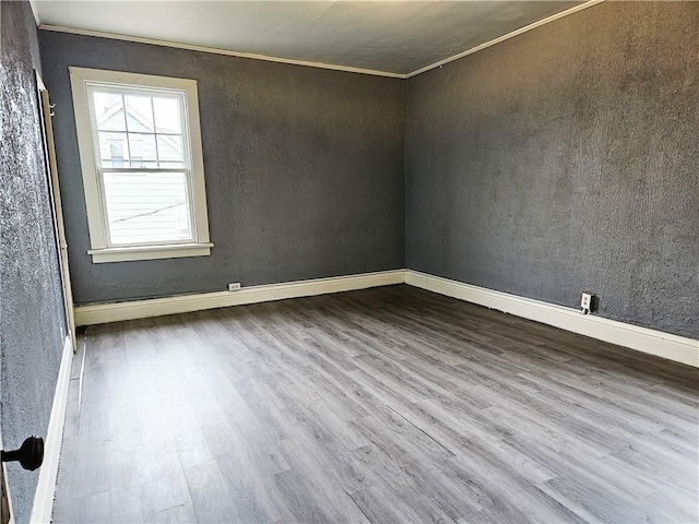 unfurnished room featuring ornamental molding and hardwood / wood-style flooring