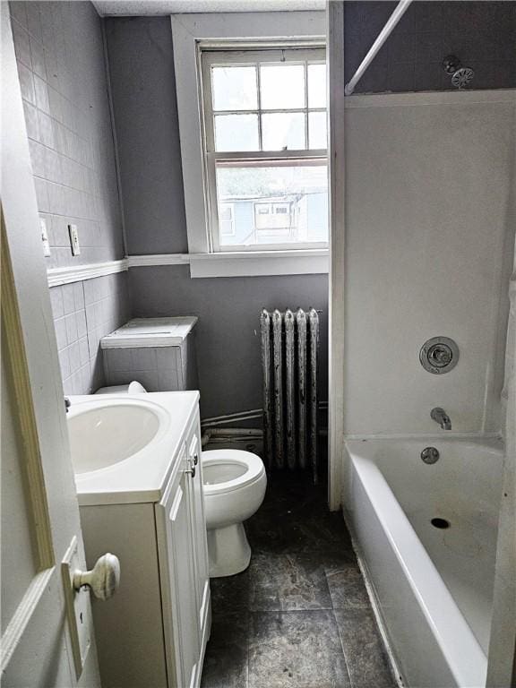 full bathroom featuring toilet, vanity, tile walls, bathing tub / shower combination, and radiator heating unit