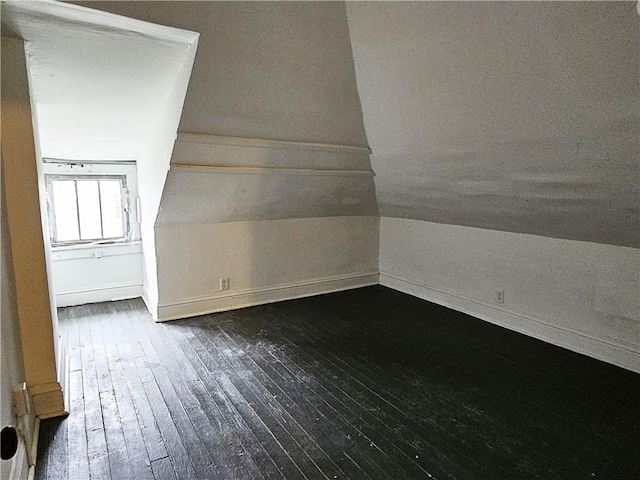 additional living space featuring dark hardwood / wood-style flooring and lofted ceiling