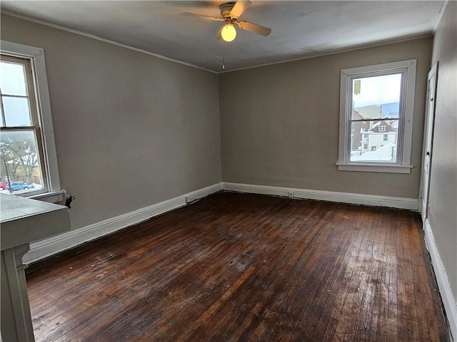 empty room with ceiling fan and dark hardwood / wood-style flooring