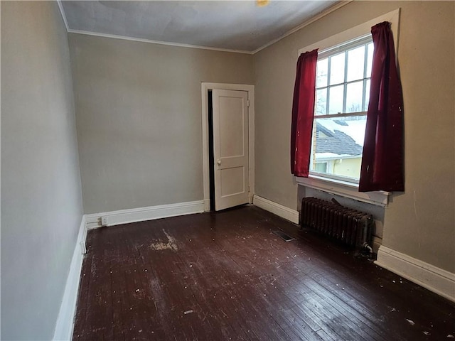 empty room with dark wood-type flooring, radiator, and crown molding