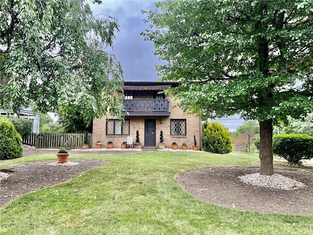 view of front of property featuring a front lawn and a balcony