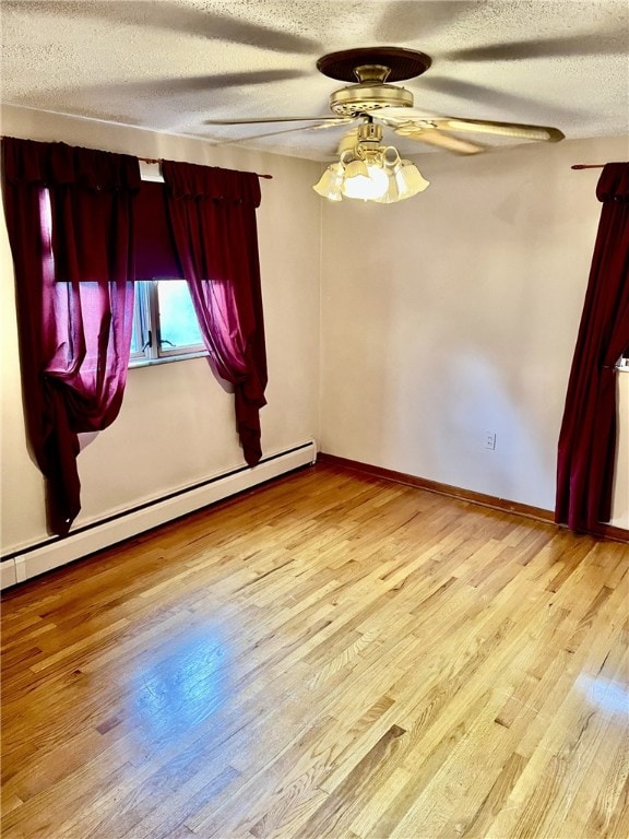 empty room featuring ceiling fan, a textured ceiling, light hardwood / wood-style flooring, and a baseboard heating unit