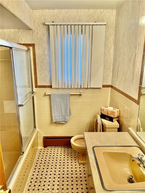 bathroom featuring vanity, a baseboard heating unit, tile patterned floors, tile walls, and toilet