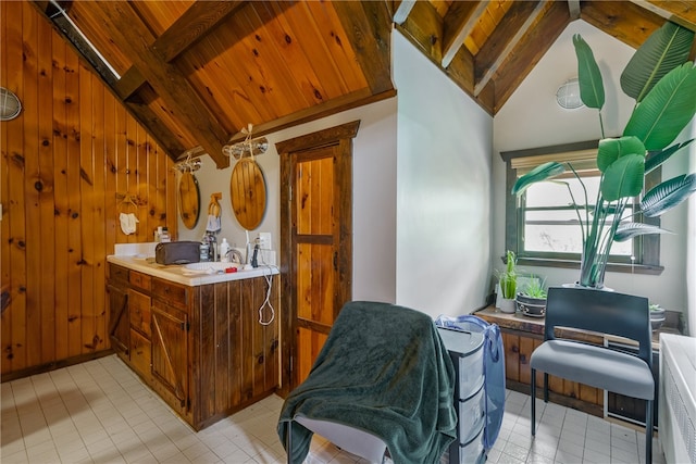 kitchen featuring wooden walls, vaulted ceiling with beams, wooden ceiling, and light tile patterned floors