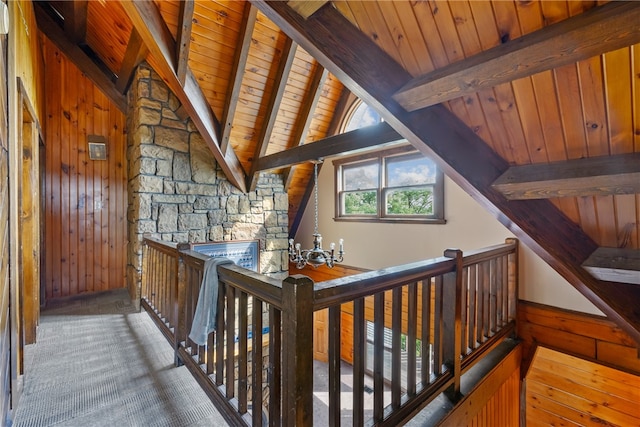 corridor with wood walls, hardwood / wood-style floors, lofted ceiling with beams, wood ceiling, and a notable chandelier