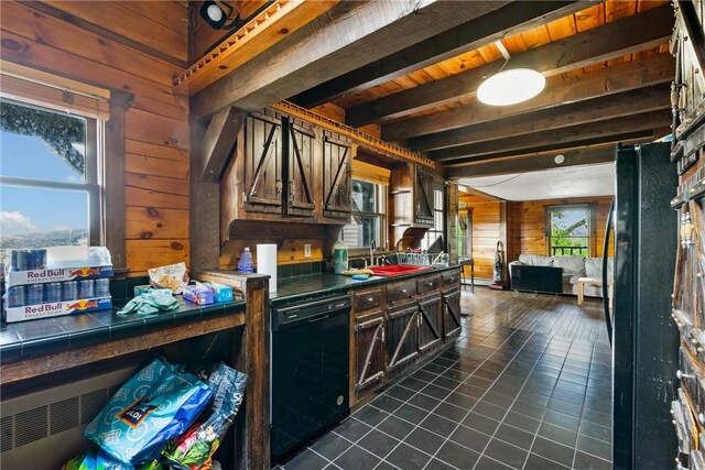 kitchen featuring wood walls, dark tile patterned floors, beamed ceiling, and dark brown cabinets