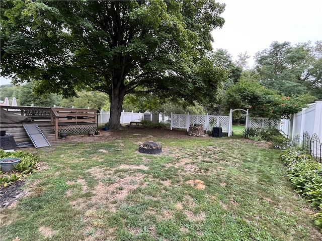 view of yard with a wooden deck and an outdoor fire pit